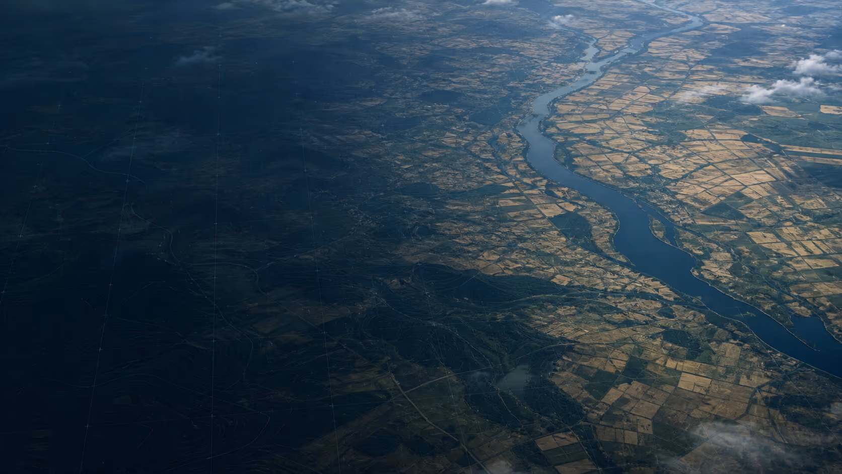 Aerial view of the Dnipro river valley in Ukraine — dark forested west bank and sunlit farmland to the east